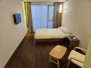 Postel nebo postele na pokoji v ubytování Tamara Jeju hotel
