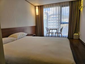 Postel nebo postele na pokoji v ubytování Tamara Jeju hotel