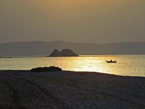 a boat on the shore of a body of water at Kiotari Coast Seaside in Kiotari