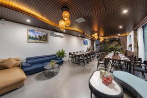 a living room with a couch and tables and chairs at Ecorest Villa Cat Ba Moutain View in Cat Ba