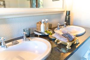 een badkamerbar met 2 wastafels en een spiegel bij Last Word Kitara in privé-wildreservaat Klaserie +90 foto's