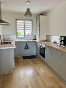 a kitchen with white appliances and a wooden floor at L'Hippocampe, terrasse, à 5 min' à pieds de la mer ! in Wimereux