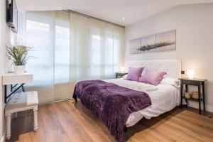 マドリードにあるPuerta Del Sol 3WCのベッドルーム(紫の毛布付きのベッド1台付)