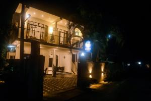 a house at night with a blue sign in front of it at Mirissa Breeze in Mirissa