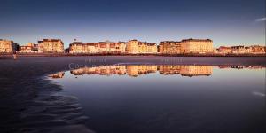 a view of a city with buildings and the water at L'Hippocampe, terrasse, à 5 min' à pieds de la mer ! in Wimereux