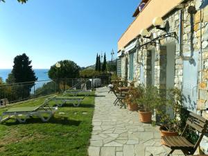 a stone building with benches on the side of it at Agriturismo La Collarina in Imperia
