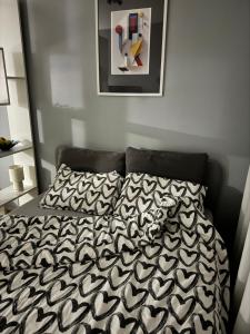 1 cama con edredón y almohadas en blanco y negro en Marse Stay, en Belgrado