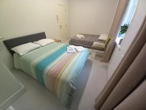 a small bedroom with a rainbow bed and a window at Chez Jean-Claude in Wavre