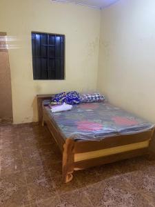 a small bed in a room with a window at Brikama line house in Brikama