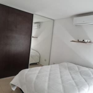 a bedroom with a white bed and a mirror at Apartamento Paris con 2 habitaciones in San Luis