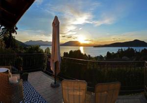 a patio with an umbrella and a view of the ocean at A casa dalla Tata B&B in Meina