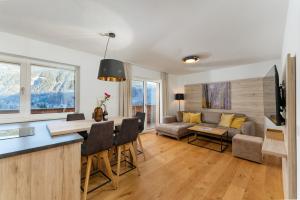 a kitchen and living room with a couch and a table at Franz Johann Appartement SKI-IN SKI-OUT by Schladming-Appartements in Schladming