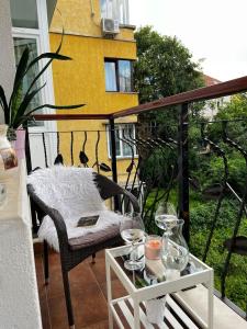 a balcony with a table with wine glasses on it at Christine's Apartment in Sofia