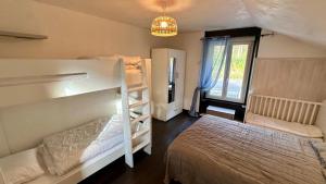 Un dormitorio con dos literas y una ventana. en Les Oréades Le Mont Dore 10pers, en Le Mont-Dore
