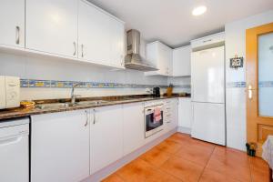a white kitchen with white cabinets and a sink at Hauzify I Apartament Riba Aurea in L'Ametlla de Mar