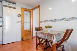 a kitchen with a table and chairs and a refrigerator at Hauzify I Apartament Riba Aurea in L'Ametlla de Mar +17 photos