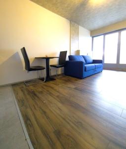 een woonkamer met een blauwe bank en een tafel bij Belle vue appart in Saint-Louis