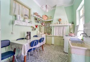 a kitchen with a table and blue chairs in it at Waterfront House Pedi in Symi