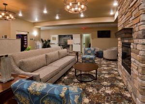 een woonkamer met een bank en stoelen en een open haard bij GrandStay Hotel & Suites Valley City in Valley City