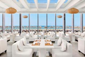 a restaurant with white furniture and a view of the ocean at Tivoli Marina Vilamoura in Vilamoura +37 photos