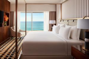a bedroom with a large bed with a view of the ocean at Tivoli Marina Vilamoura in Vilamoura