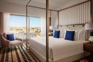 a bedroom with a bed and a chair and a window at Tivoli Marina Vilamoura in Vilamoura