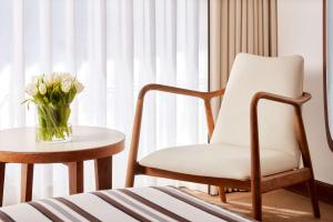 a vase of flowers sitting on a table next to a chair at Tivoli Marina Vilamoura in Vilamoura