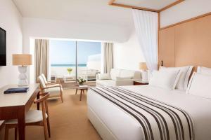 a hotel room with a large bed and a desk at Tivoli Marina Vilamoura in Vilamoura