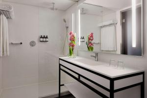 a white bathroom with a sink and a shower at Tivoli Marina Vilamoura in Vilamoura