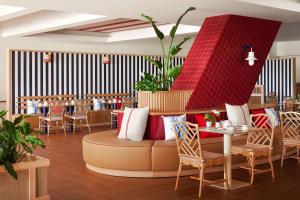a restaurant with a couch and tables and chairs at Tivoli Marina Vilamoura in Vilamoura