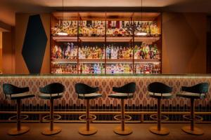 a bar with black stools in front of a bar at Tivoli Marina Vilamoura in Vilamoura