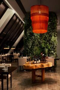 a restaurant with a large green wall with wine bottles on a table at Tivoli Marina Vilamoura in Vilamoura