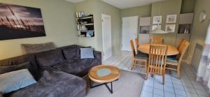 a living room with a couch and a table at Nr 96 - Ferienhaus Uferstraße in Carolinensiel +17 photos