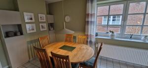 a dining room with a wooden table and chairs at Nr 96 - Ferienhaus Uferstraße in Carolinensiel