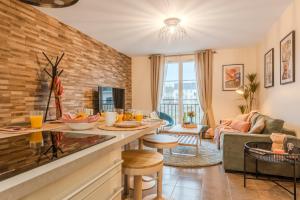 an open living room with a brick wall at Agora by Kleidos - Bel appartement T3-6 personnes, Disney 10 mn, parking gratuit in Magny-le-Hongre
