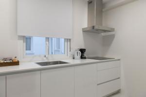 Una cocina con gabinetes blancos y un fregadero. en La Bodega Con Parking Gratis, en Córdoba 25 fotos más