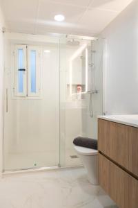 Un baño con ducha de cristal y un inodoro. en La Bodega Con Parking Gratis, en Córdoba