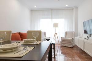 una sala de estar con una mesa con platos y copas de vino en La Bodega Con Parking Gratis, en Córdoba