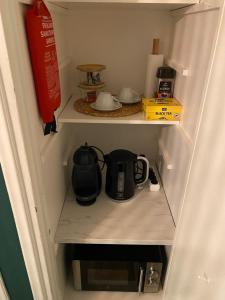 a small refrigerator with a tea kettle in it at Studio Brahe in Helsinki