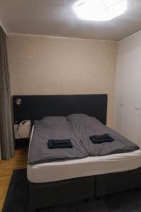 Una cama con dos toallas negras encima. en Luxury apartment with sauna, grill and garage, en Tampere