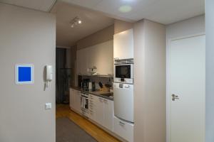 una cocina con armarios blancos y un horno de fogón blanco en Luxury apartment with sauna, grill and garage, en Tampere 11 fotos más