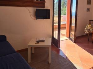un soggiorno con un tavolo e una TV di CASA OLEANDRO a Finale Ligure