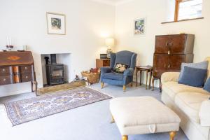a living room with a couch and a stove at The Coach House in Saint Fillans