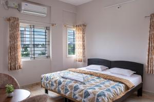 a bedroom with a large bed and two windows at WHITE HOSUE LIVING iNN in Bengaluru