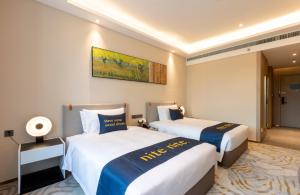 A bed or beds in a room at The Mulian Hotel, Chengdu Frontier Medical Center