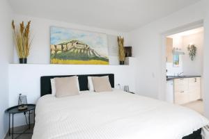 a white bedroom with a large white bed in it at Villa Amarilis in Casas Albardanera