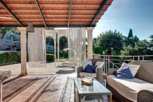 an outdoor patio with a couch and a table at Villa Demetra Capri - Pool and Relaxation in Anacapri