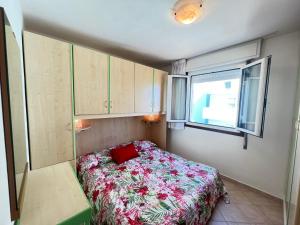 a small bedroom with a bed and a window at Condominio ADRIATICO in Bibione