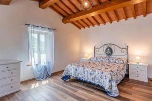 Un dormitorio con una cama y suelo de madera. en Casa Vacanze Legnana, en Borgo a Mozzano 38 fotos más