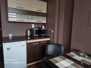 a small kitchen with a table and a microwave at Akmerenta 7 - 2 in Akmenė